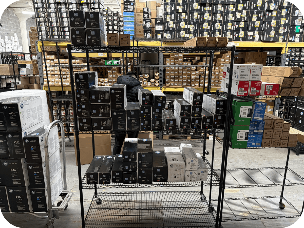 An office supply room containing organized factory-sealed toner left after a printer fleet upgrade.
